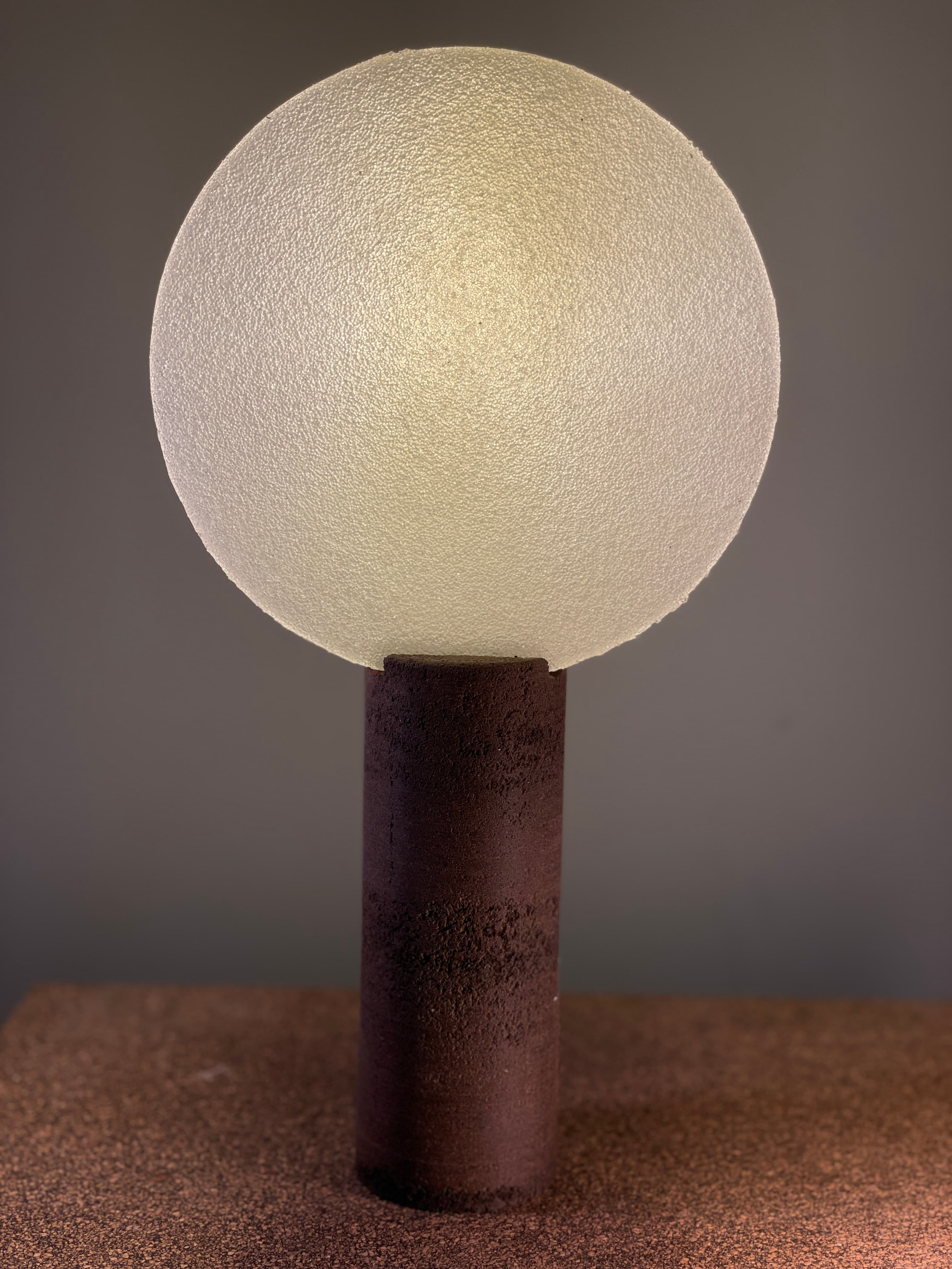 Spherical textured glass lamp on a dark cylindrical base